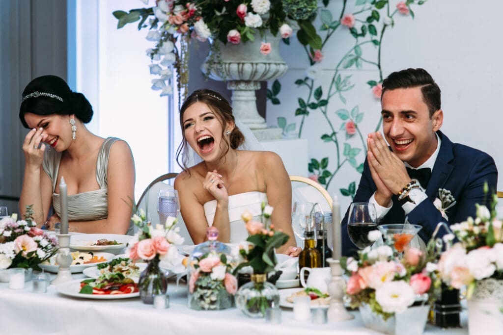 Wedding party laughing at a decorated reception table